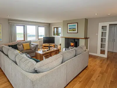 a living room with a large couch and a television at Corsewall Castle Farm Lodges in Kirkcolm
