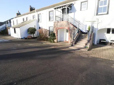 a white house with a staircase in front of it at Greenmantle in Skinburness