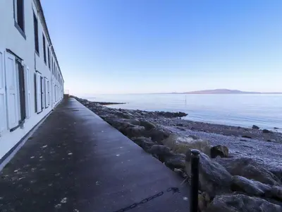 a sidewalk next to a building next to the water at Greenmantle in Skinburness