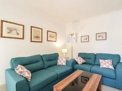 a living room with two blue couches and a coffee table at 1 Rubby Banks Road in Cockermouth