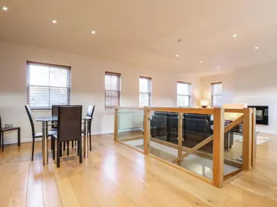 a dining room and living room with a table and chairs at Wrenville in Keswick