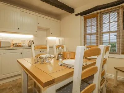 a kitchen with a wooden dining room table and chairs at Ale Cottage in Ireby