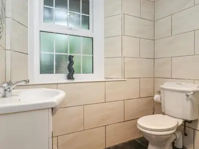a bathroom with a toilet and a sink and a window at Coombe Cottage in Borrowdale Valley