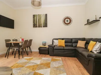 a living room with a black couch and a table at St Johns View in Keswick