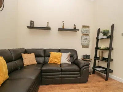 a black leather couch sitting in a living room at St Johns View in Keswick