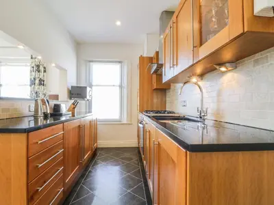 a kitchen with wooden cabinets and black counter tops at Helvellyn in Keswick