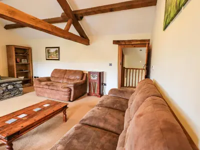 a living room with a couch and a table at Scales Cottage in Lorton