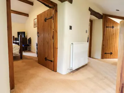 a hallway with wooden doors in a house at Scales Cottage in Lorton