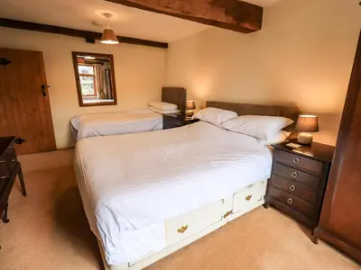 a bedroom with two beds and a desk with two lamps at Scales Cottage in Lorton
