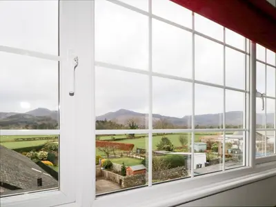 a window with a view of a countryside seen through it at Fountain Cottage in Keswick