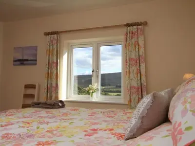 a bedroom with a bed and a window at Eribel Cottage in Threlkeld