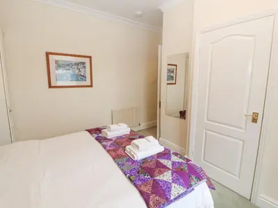 a white room with a bed with towels on it at White House in Keswick