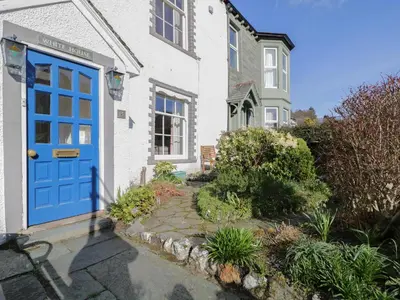 a blue door on a white house with a garden at White House in Keswick