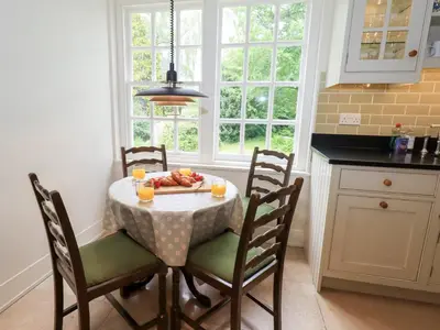 a kitchen with a table with a plate of fruit on it at Little Ellers in Portinscale