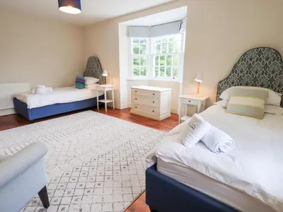 a bedroom with two beds and a window at Little Ellers in Portinscale
