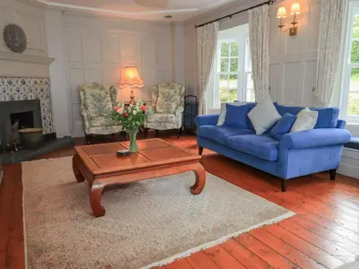 a living room with a blue couch and a table at Little Ellers in Portinscale