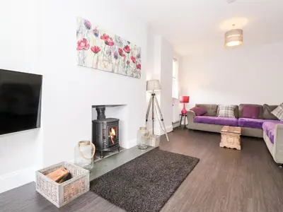 a living room with a couch and a fireplace at Latrigg House in Keswick