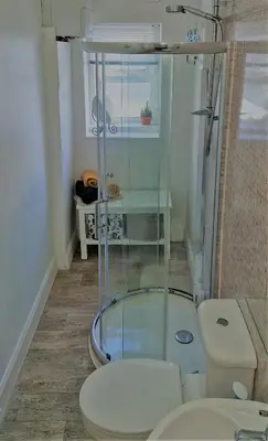 a bathroom with a glass shower and a toilet at Troon Beachcombers in Troon