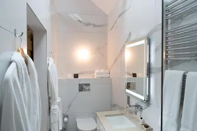 a white bathroom with a sink and a mirror at Pentonbridge Inn - Restaurant with Rooms in Carlisle