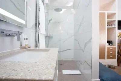 a white bathroom with a tub and a sink at Pentonbridge Inn - Restaurant with Rooms in Carlisle