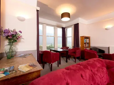 a living room with a red couch and a table at YHA Buttermere in Buttermere