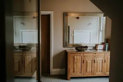 a bathroom with a mirror and a wooden cabinet at Troutbeck Inn in Troutbeck