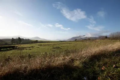 a field of grass with mountains in the background at Troutbeck Inn in Troutbeck