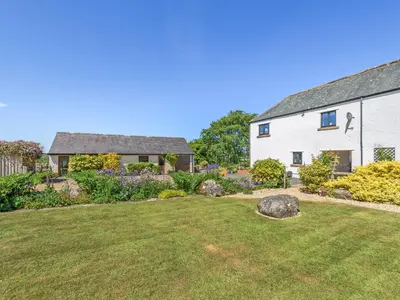 a white house with a yard and a garden at New Park Farm - Church Cottage in Ireby