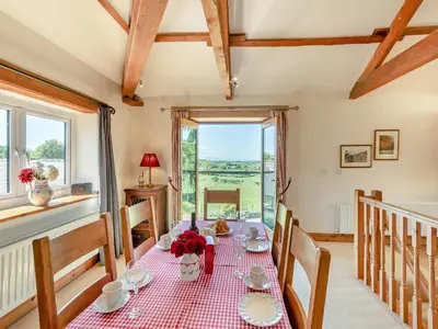 a dining room with a table and chairs and a window at New Park Farm - Church Cottage in Ireby