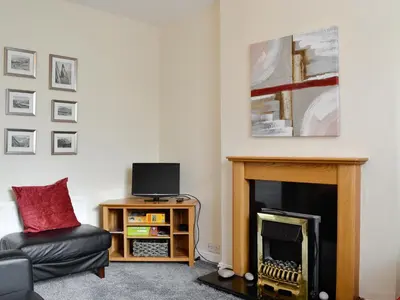 a living room with a fireplace and a chair at Walla Crag in Keswick
