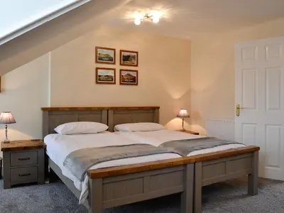 a bedroom with a bed and two lamps and a staircase at Walla Crag in Keswick