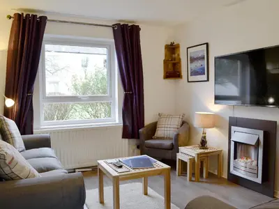 a living room with a couch and a fire place at Philip's Cottage in Keswick
