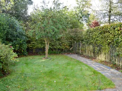 a tree in a yard next to a fence at Philip's Cottage in Keswick