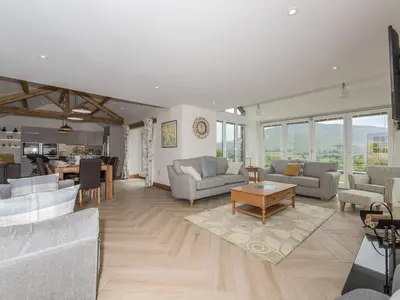 a large living room with couches and a table at The Hoggest in Threlkeld