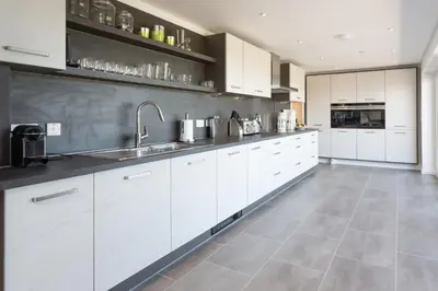 a large kitchen with white cabinets and a tile floor at Links View - Donnini Deluxe in Prestwick