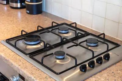 a stove top with four burners on a kitchen counter at Carrick Retreat - Donnini Apartments in Ayr