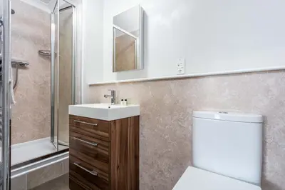 a bathroom with a toilet and a sink and a shower at Carrick Retreat - Donnini Apartments in Ayr