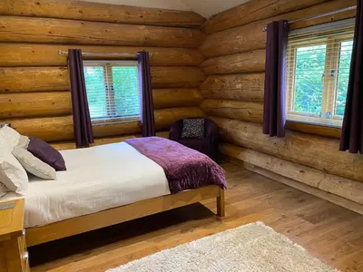 a bedroom with a bed in a log cabin at Ewes Water Log Cabins in Langholm