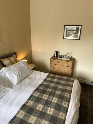 a bedroom with a bed and a wooden dresser at No 4 Portpatrick B&B in Portpatrick