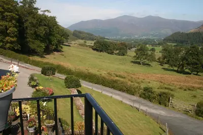 a balcony with a view of a field and mountains at StoneyGill in Keswick