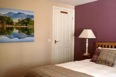 a bedroom with a bed and a painting on the wall at StoneyGill in Keswick