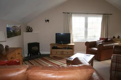 a living room with a couch and a television at StoneyFell in Keswick