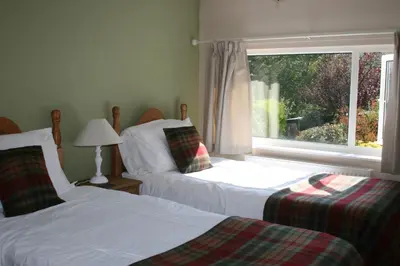 two beds in a room with a window at StoneyFell in Keswick