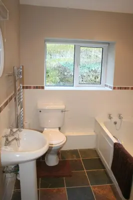 a bathroom with a toilet and a sink and a tub at StoneyFell in Keswick