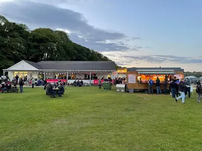 a group of people standing in a field near a market at IntentsGP @ Isle of Man TT, IOMTT in Douglas