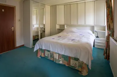 a bedroom with a large white bed in a room at Dairy Cottage in Ayr