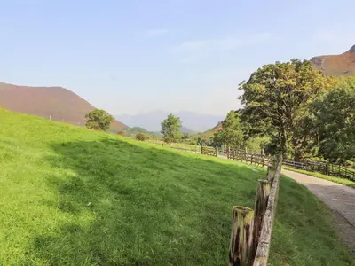 a fence on the side of a grassy field at The Hayloft in Keswick