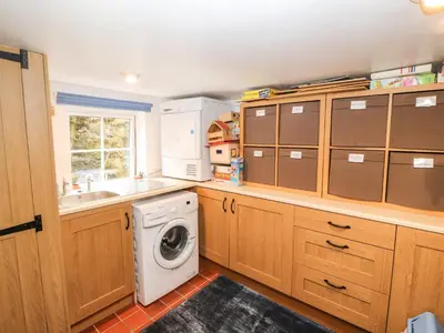 a kitchen with a washer and dryer at Fell Cottage in Wigton