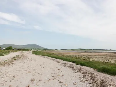 a dirt road next to a field of grass at The Bothy in Mainsriddle