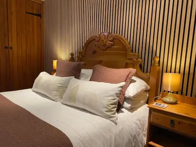 a bedroom with a large bed with white pillows at Stable Cottage in Wigton
